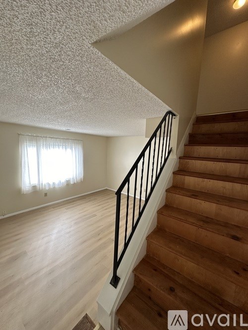 A staircase with wooden steps and a black railing.