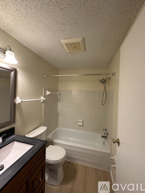 A bathroom with a toilet, sink, and bathtub.