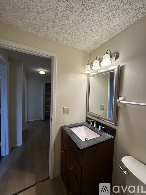 A bathroom with a sink, mirror, and toilet.