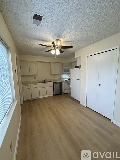 A kitchen with white cabinets and a ceiling fan.