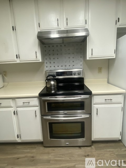 A kitchen with a stove and oven built into the cabinetry.