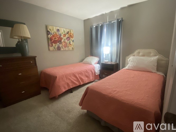 Two twin beds in a room with a painting on the wall.