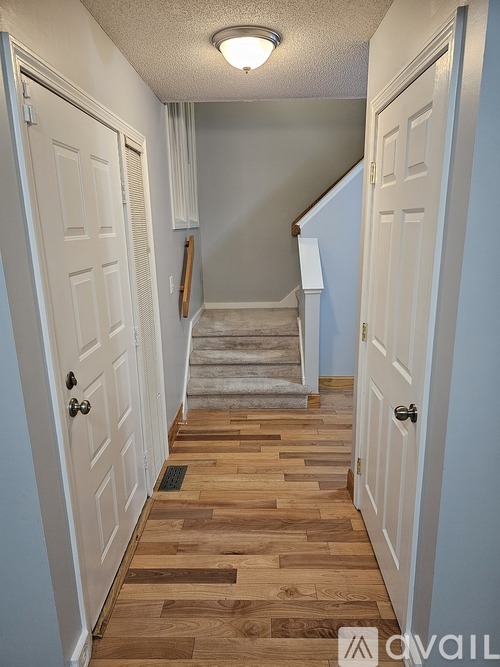 A hallway with wooden floors and white doors.