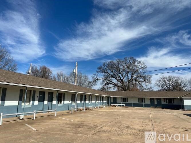 A large, open parking lot in front of a building with a blue and white exterior.