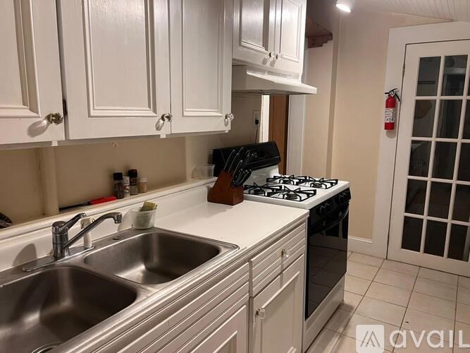 A kitchen with white cabinets and a stove top oven.