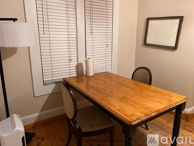 A wooden table with a chair and a lamp in a room.