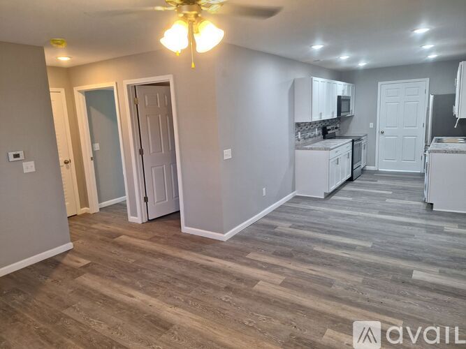 A room with a ceiling fan and wooden flooring.