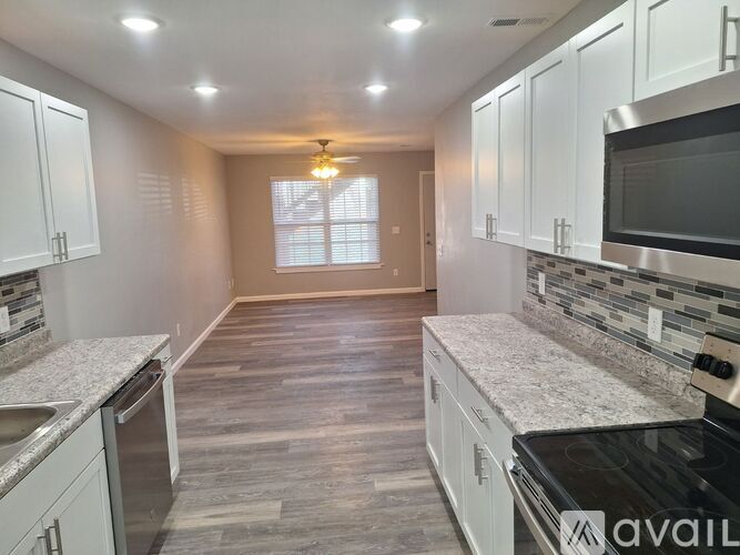 A kitchen with white cabinets and a granite countertop.