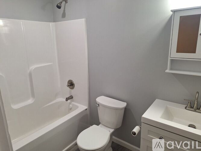 A white toilet sits next to a white sink in a bathroom.
