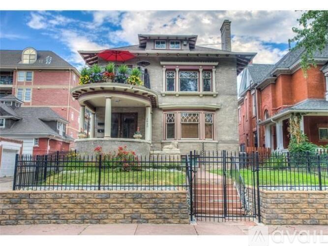 A large house with a red umbrella on the front porch.