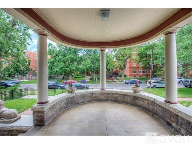 A covered walkway with columns and a stone bench.