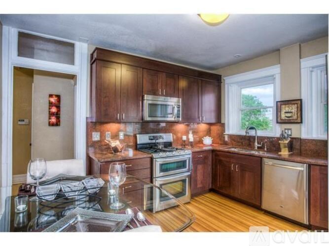 A kitchen with wooden cabinets and a stove top oven.