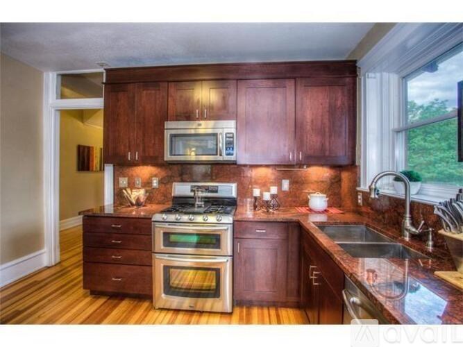 A kitchen with wooden cabinets and a stove top oven.