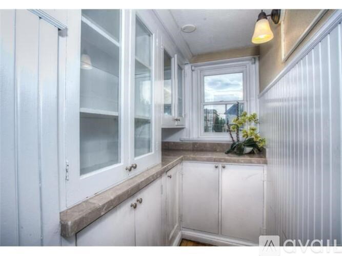 A kitchen with white cabinets and a window.