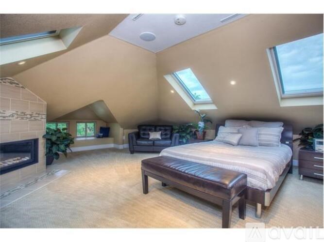 A bedroom with a large bed and a fireplace.