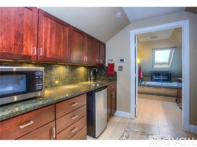 A kitchen with wooden cabinets and a microwave on the counter.