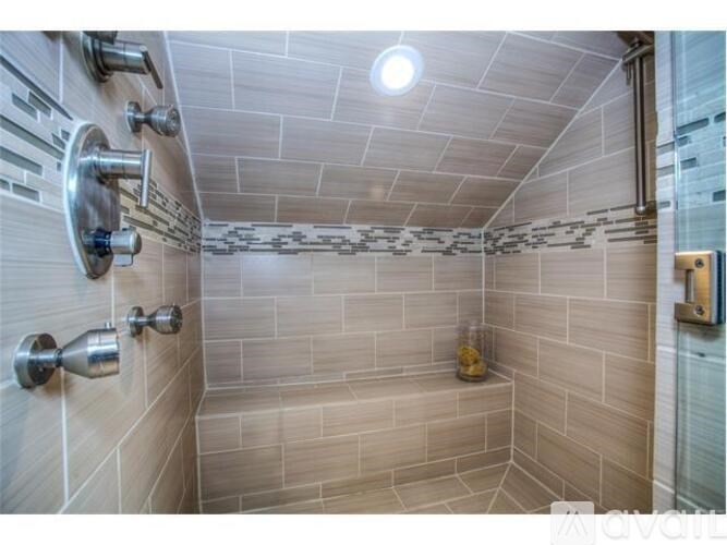A shower area with a glass door and a shower head.