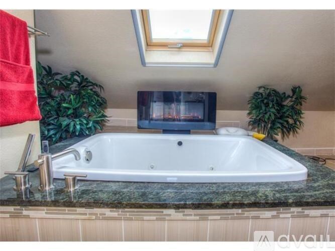 A bathroom with a jacuzzi tub and a television.