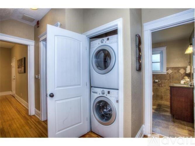 A white door opens to a laundry room with a washer and dryer.