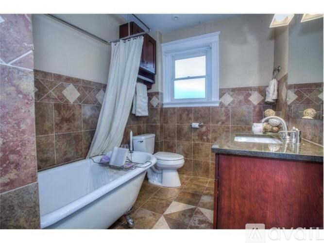 A bathroom with a tub, toilet, and sink.