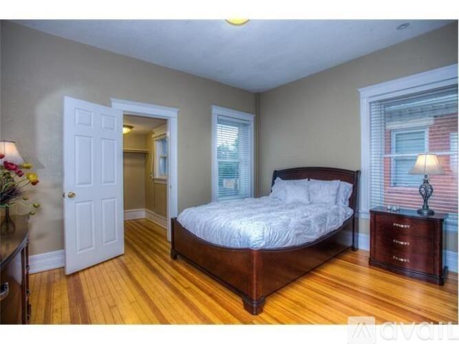 A bedroom with a bed, dresser, and a window.