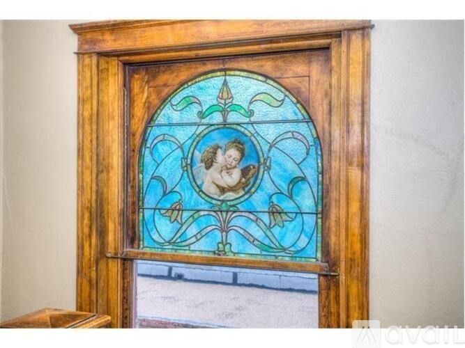 A stained glass window with a wooden frame is in the foreground.