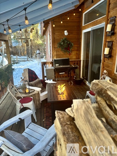 A wooden deck with a table and chairs and a laptop on it.