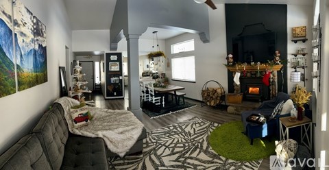A living room with a grey couch and a painting on the wall.