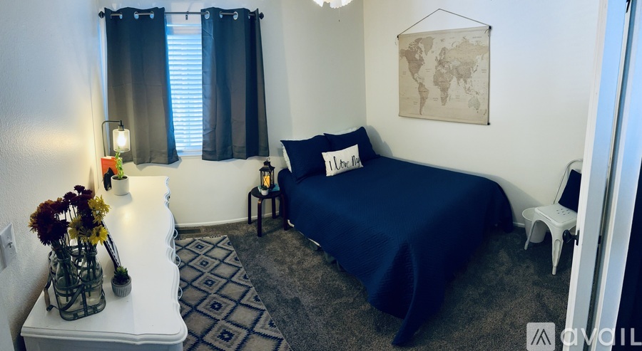 A bedroom with a bed, nightstand, and a world map on the wall.