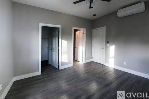 A room with a ceiling fan and a doorway leading to another room.