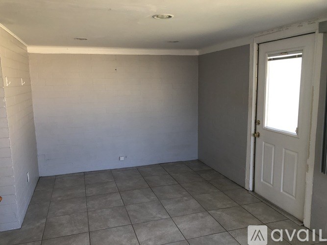 A room with a door and tiled floor.