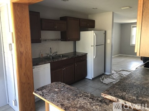 A kitchen with granite countertops and a white refrigerator.