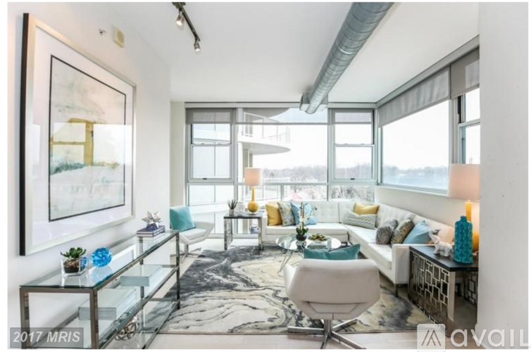 A living room with a glass table and a white chair.