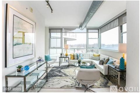 A living room with a glass table and a white chair.