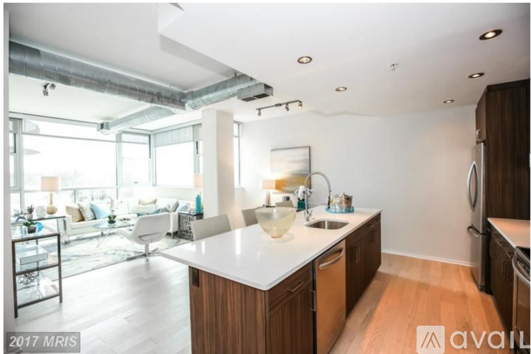A kitchen with a white countertop and wooden cabinets.
