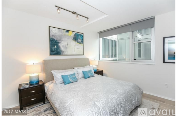 A bedroom with a large bed and a painting on the wall.
