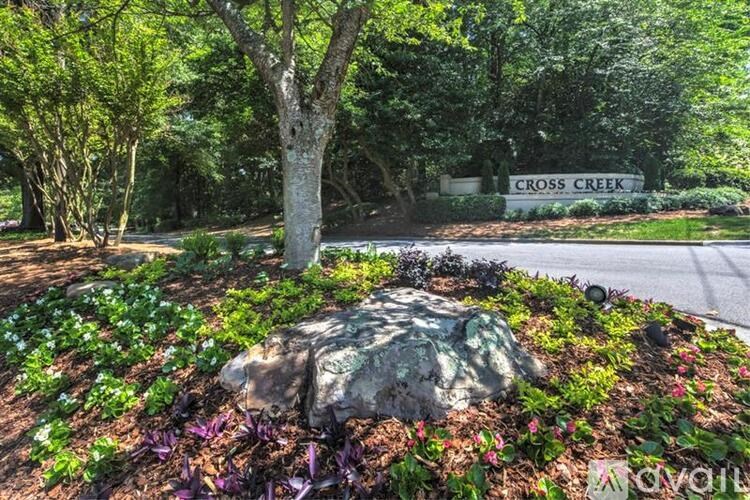 A garden with a rock in the middle and a sign that says Cross Creek.