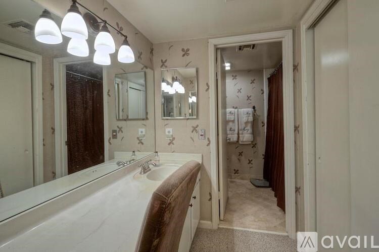 A bathroom with a white sink and brown towel.