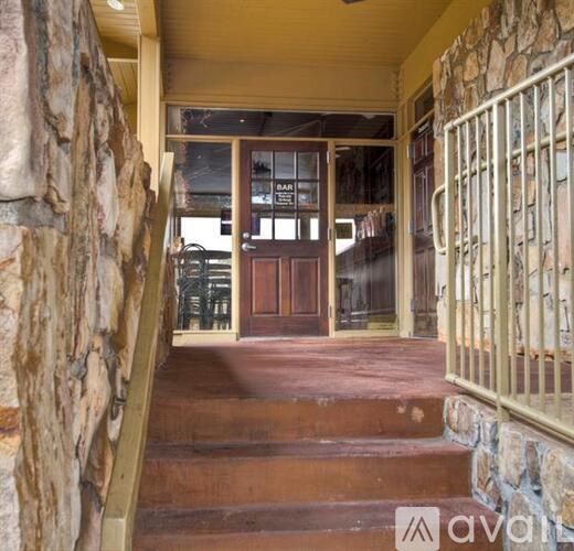 A stone wall with a staircase leading to a wooden door.