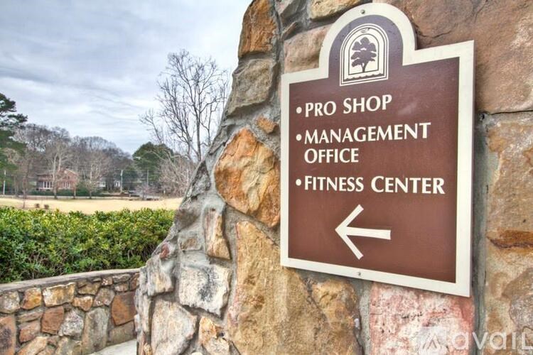 A brown sign with white text points to the left for the Pro Shop, Management Office, and Fitness Center.