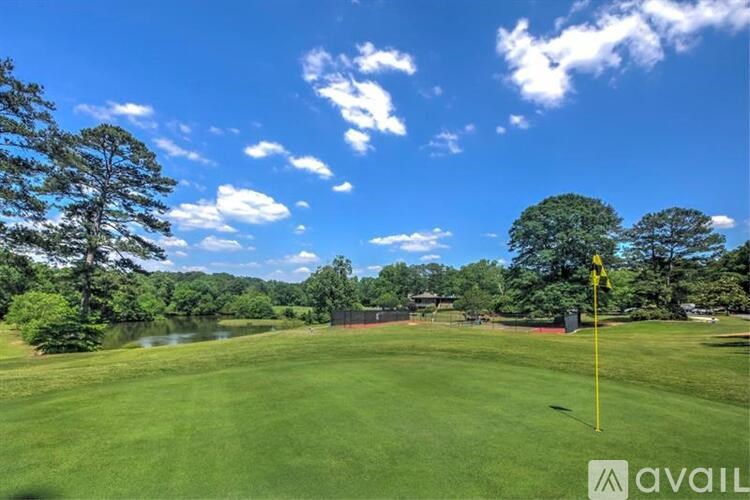 A golf course with a yellow flag on the green.