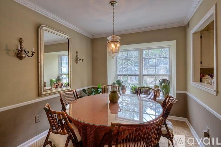 A dining room with a round table and chairs.