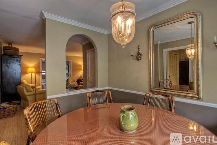 A dining room with a round table and chairs.