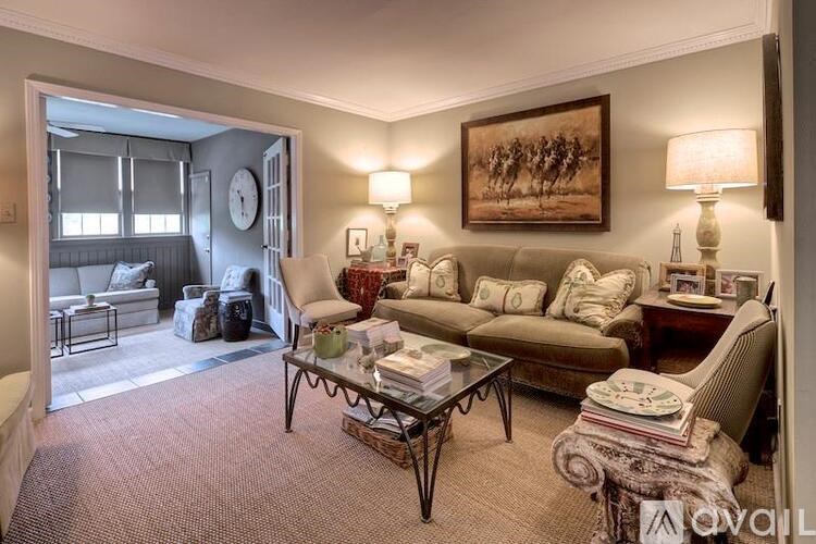 A living room with a sofa, armchair, and coffee table.