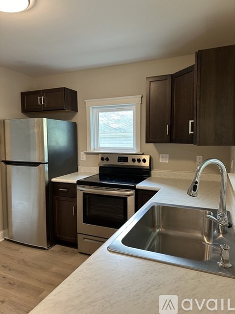 A kitchen with a stainless steel sink and a window.