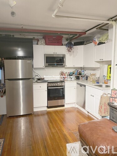 A kitchen with white cabinets and a wooden floor.