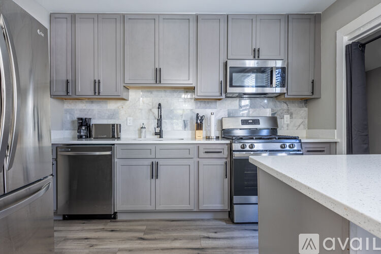 A kitchen with a refrigerator, oven, and microwave.