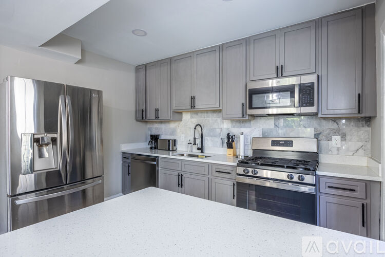 A kitchen with a stainless steel refrigerator and a white countertop.