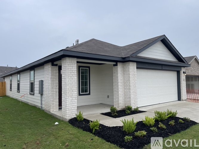 A house with a white exterior and a black roof is for sale.