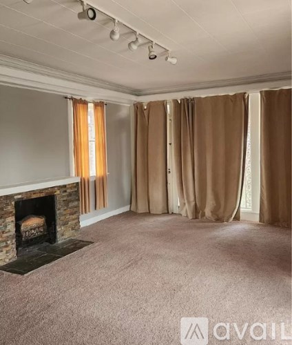 A living room with a fireplace and carpeted floor.